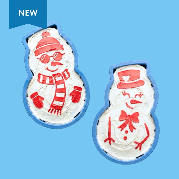 Two snowman-shaped cookies with red and white decorations on a blue background. NEW