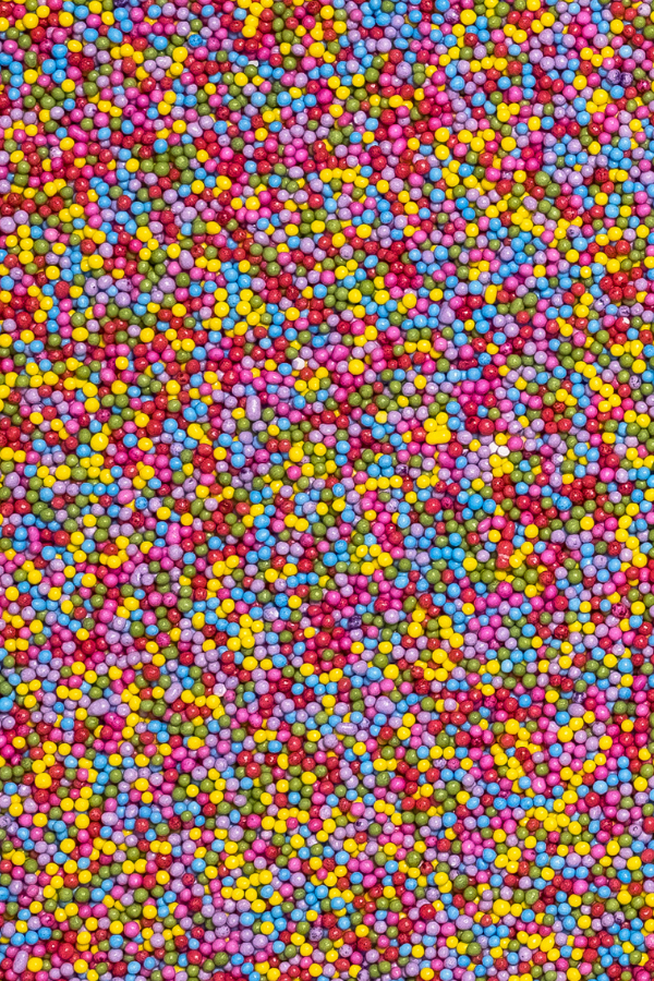 Multicolored naturally colored nonpareil sprinkles photographed as a background.