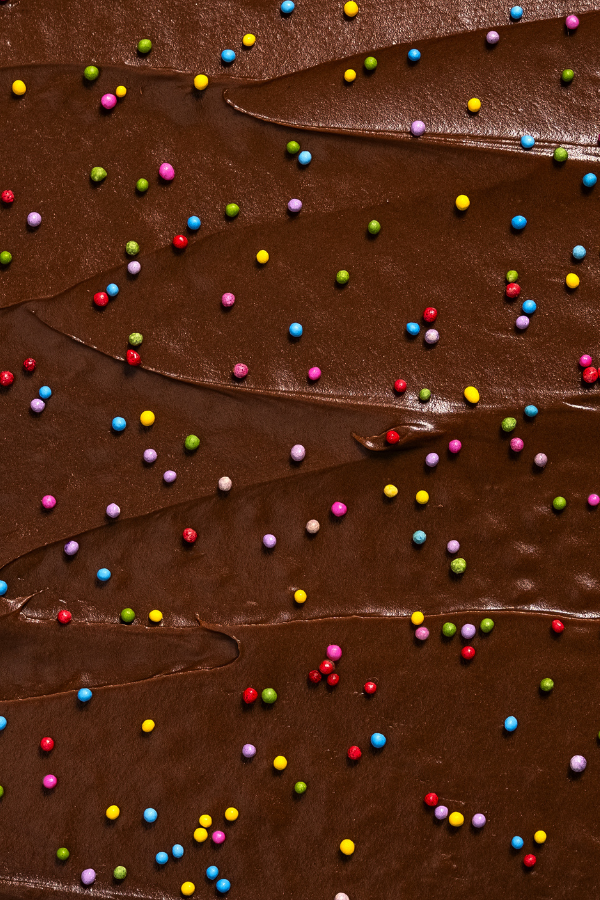 Photograph of colorful natural sprinkles on a chocolate cake.