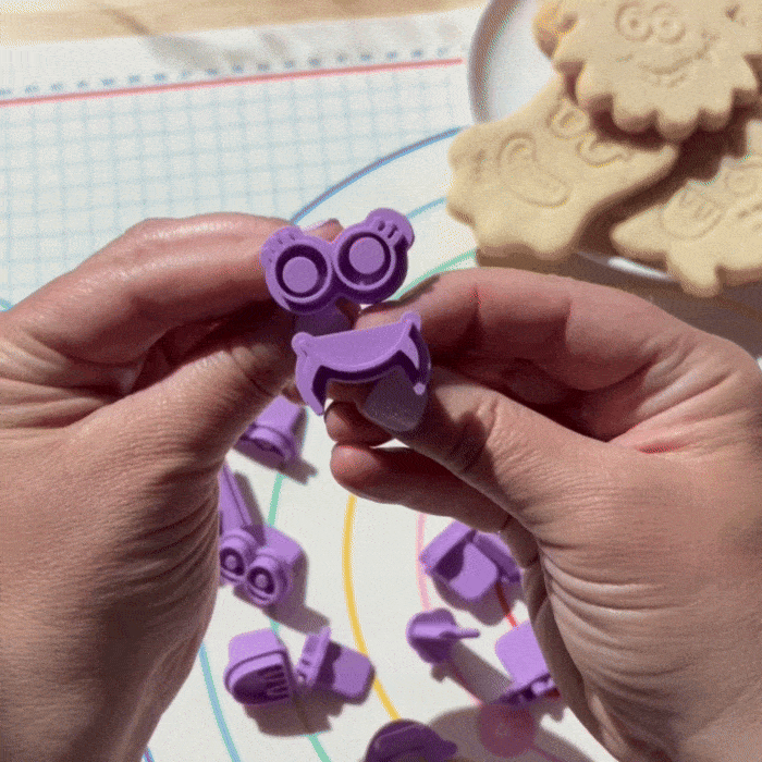 Video of a close of hands showing different combinations of monster face cookie stamps