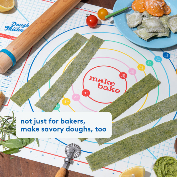 Wood rolling pin with dough thickness rings shown making homemade pasta on a silicone dough mat for baking.