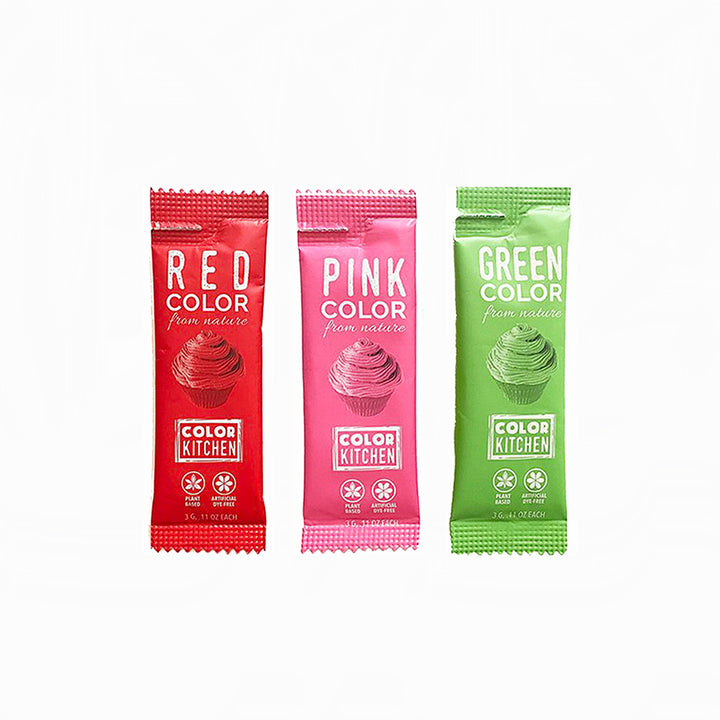 Three packets of powdered food coloring in red, pink, and green, labeled 'Color Kitchen' and 'Dye-Free'.