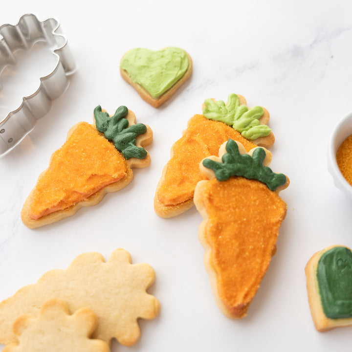 close up of carrot cookies decorated with dye free sanding sugars and naturally colored icing