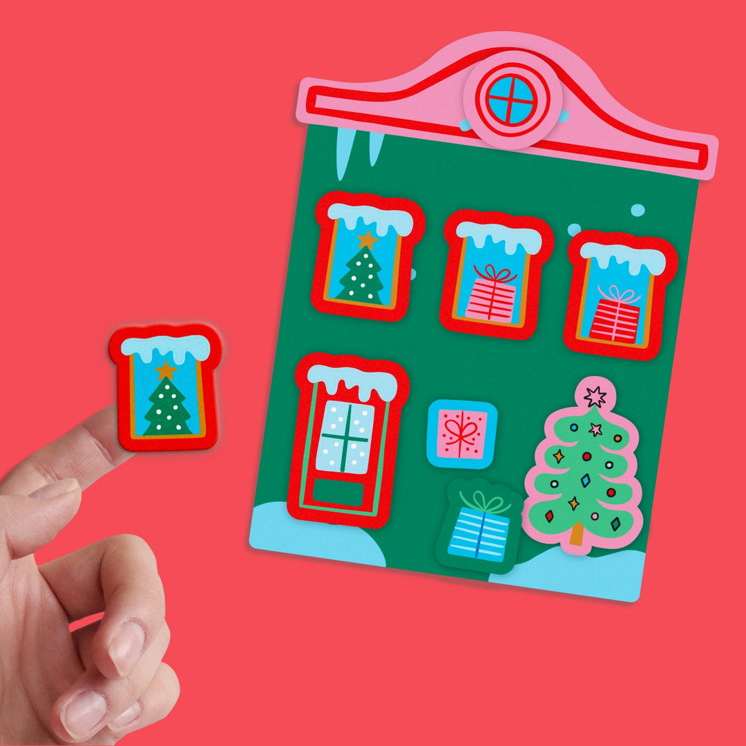 Christmas-themed house sticker set with a hand holding one of the stickers against a red background