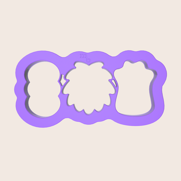 Image of purple plastic cookie cutter that cuts three monster-shaped cookies in one press.