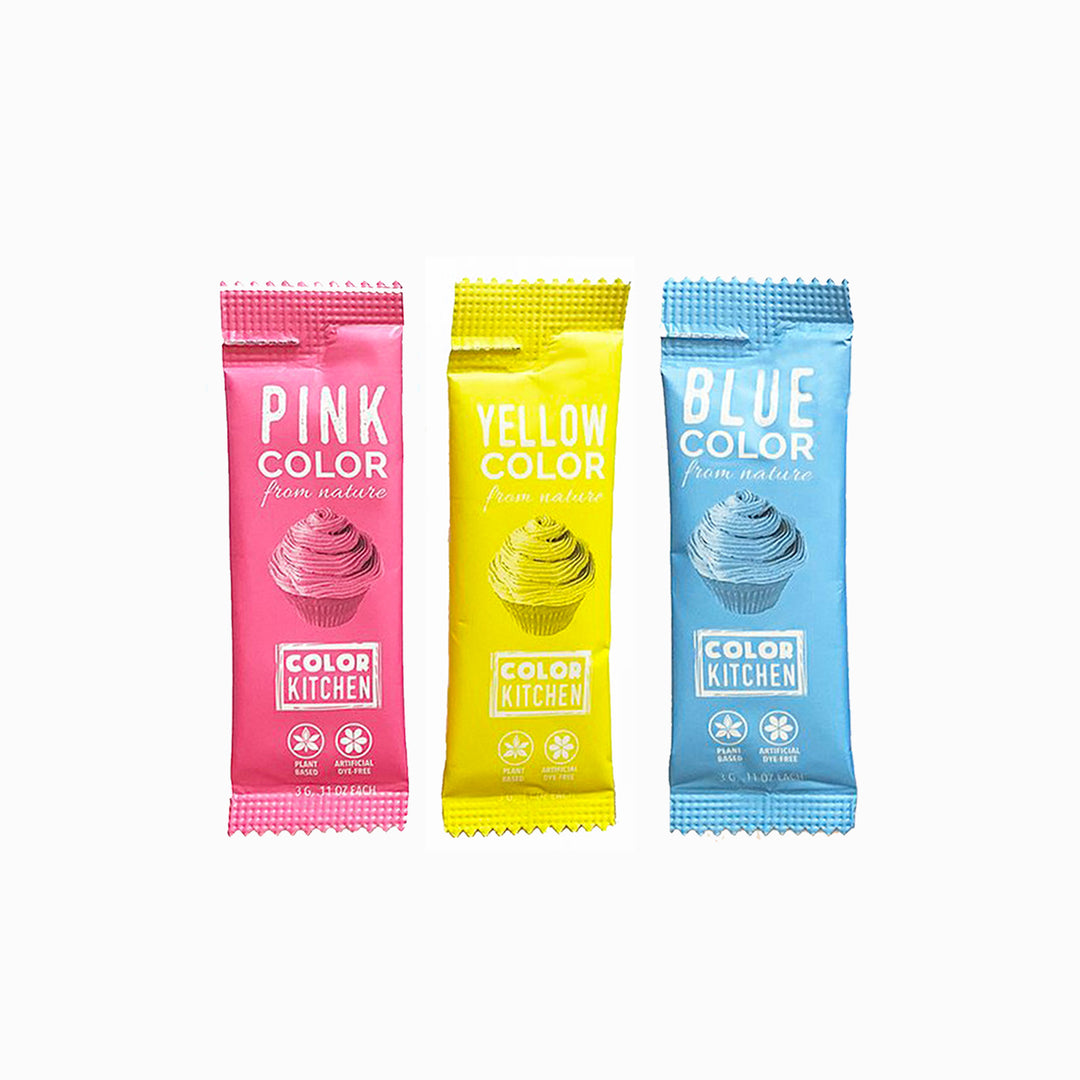 Three packets of dye-free powdered food coloring in pink, yellow, and blue, each labeled with the respective color name and the brand 'Color Kitchen'.