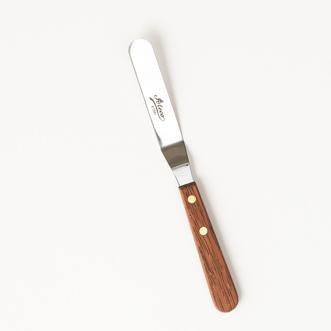 Spatula with wooden handle and metal blade on a white background
