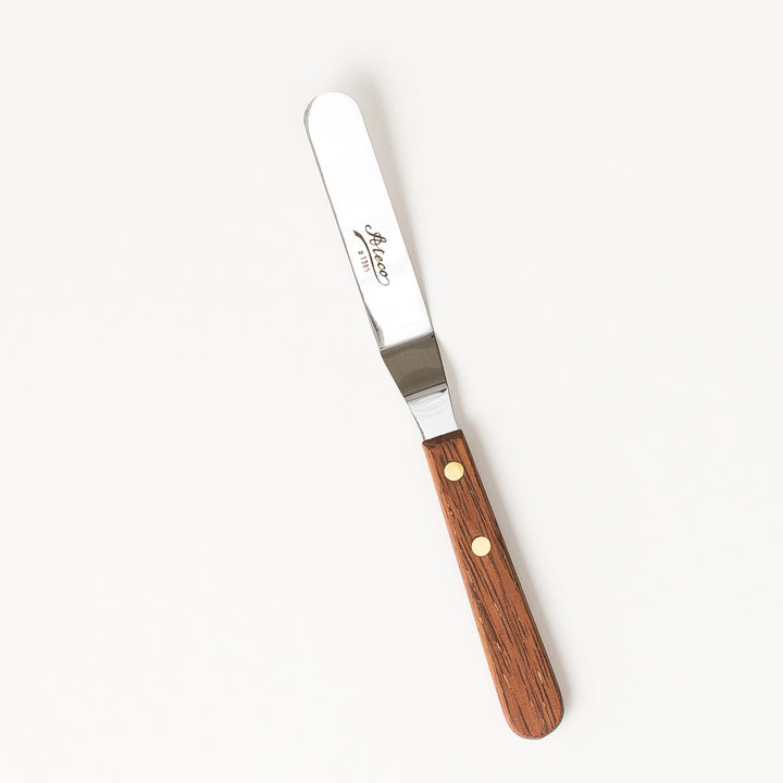 Spatula with wooden handle and metal blade on a white background