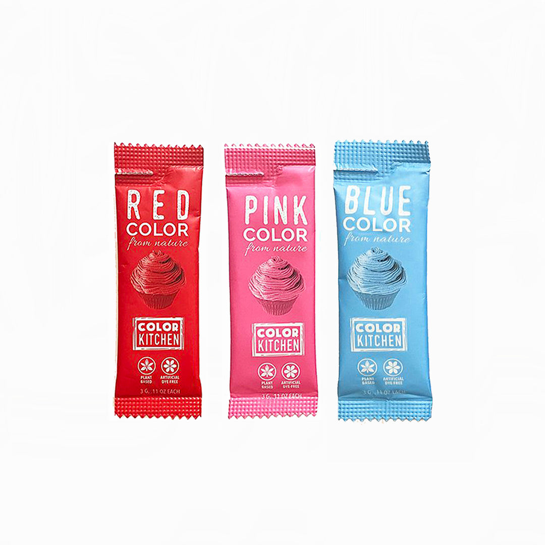Three dye-free Color Kitchen color packs in red, pink, and blue on a white background